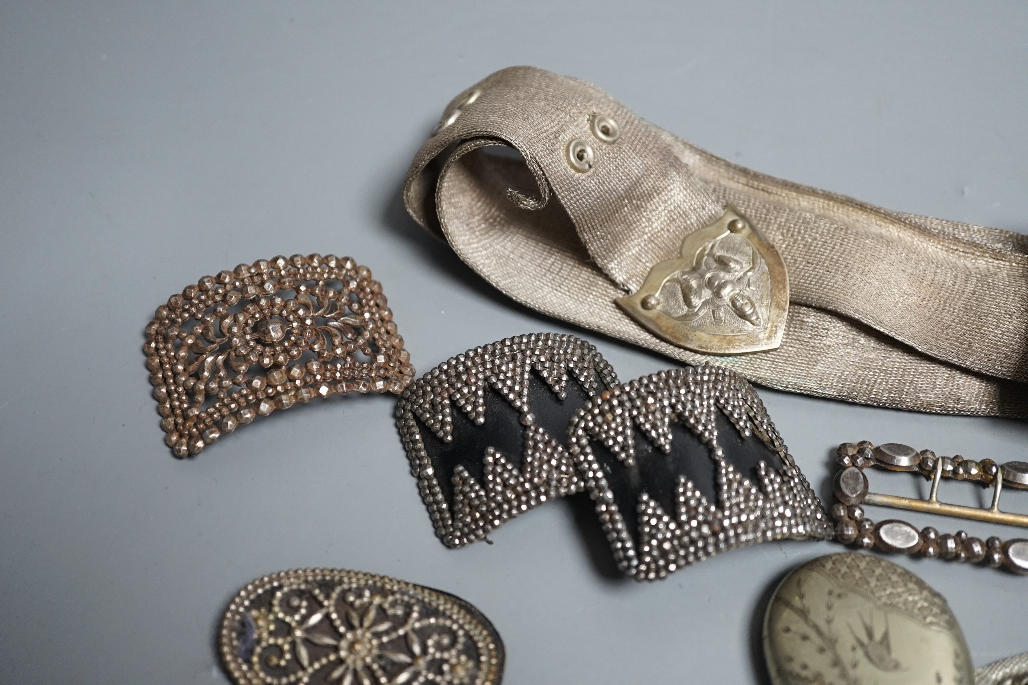 An Indian metal belt, four assorted metal shoe buckles and an aesthetic engraved silver plated vesta case.